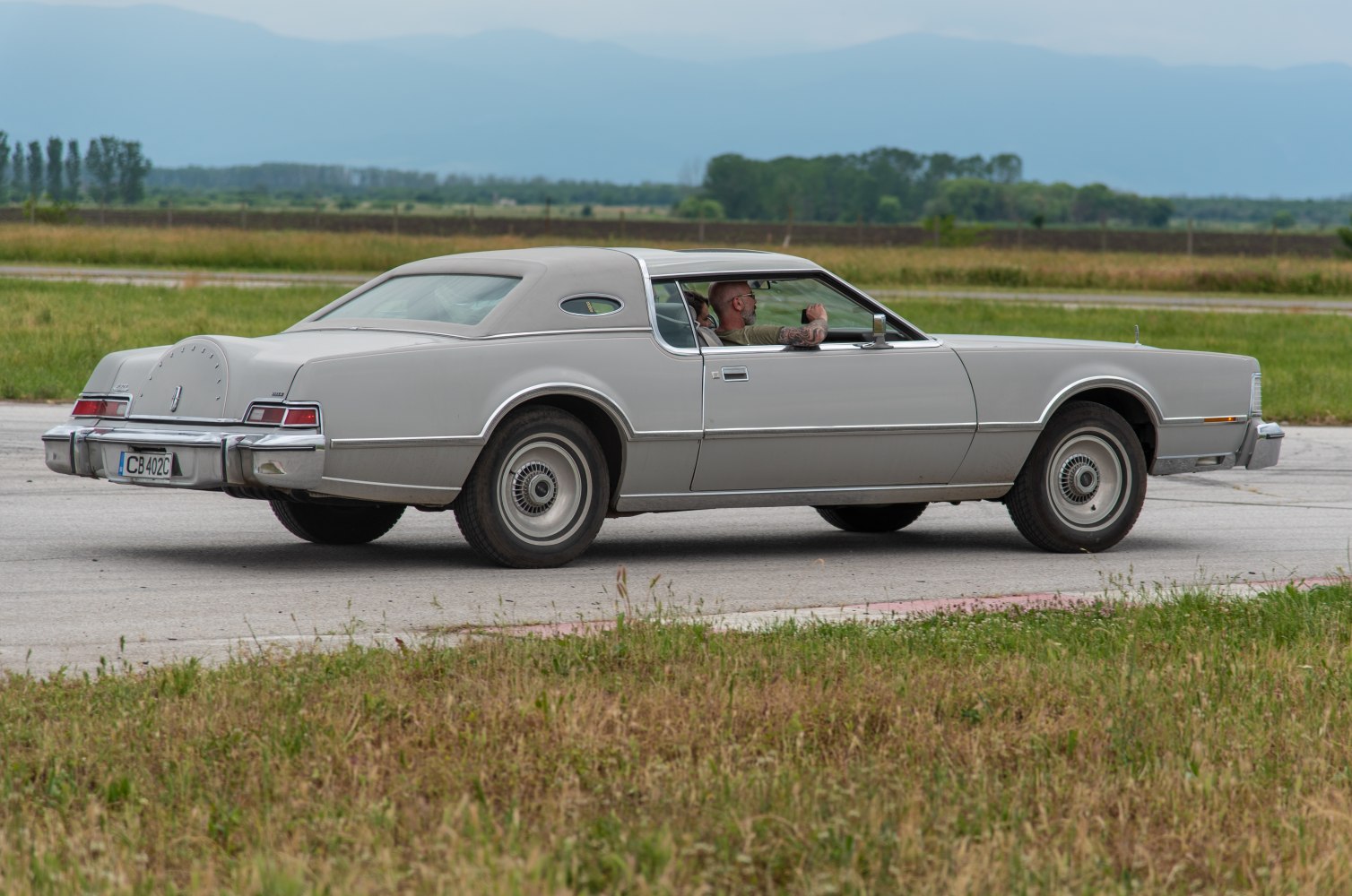 Side profile of a long vintage coupe with rear spare tire hump
