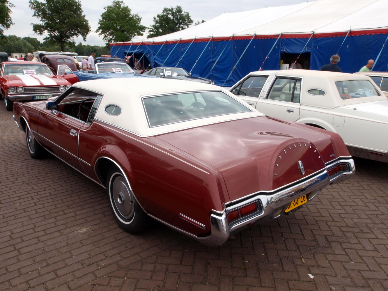 Vintage luxury coupe with white vinyl roof and distinctive spare tire trunk