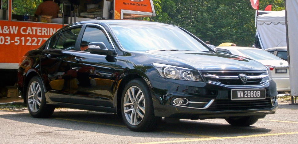 Front-side view of black modern sedan with alloy wheels and daytime running lights