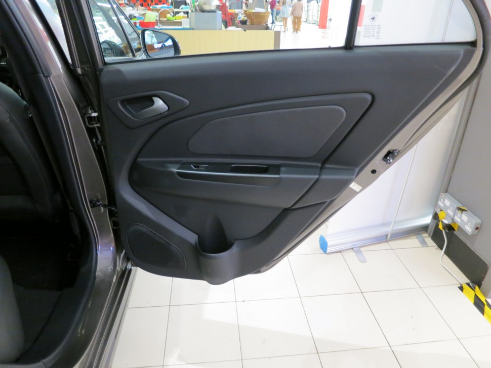 Rear door interior panel with handle, speaker, and storage compartment.