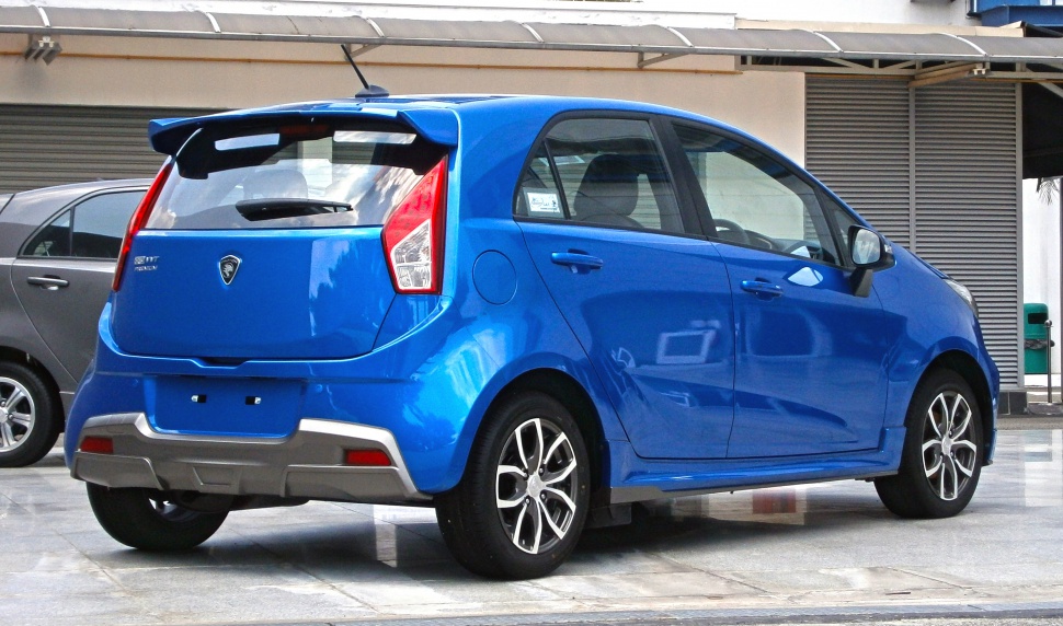Rear side view of blue hatchback with spoiler and alloy wheels