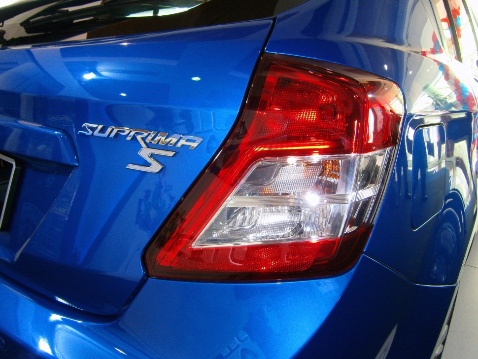 Close-up of rear taillight and Suprima S badge on blue car