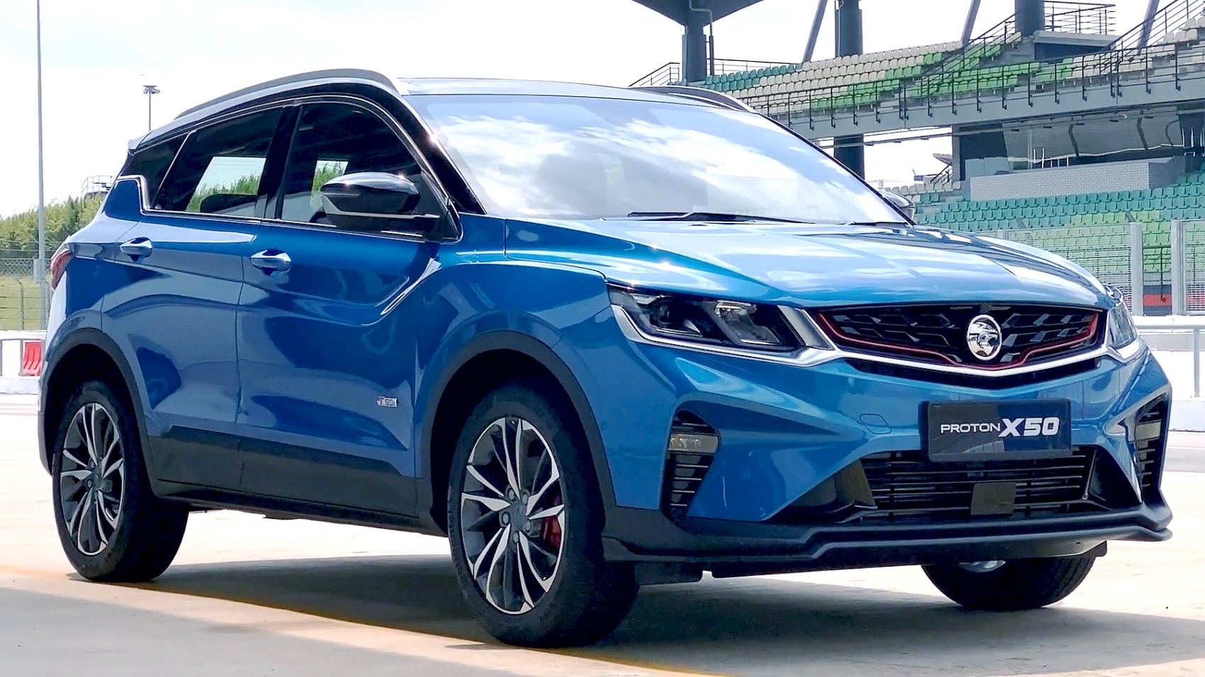Front side view of blue compact SUV with aggressive headlights and sporty design
