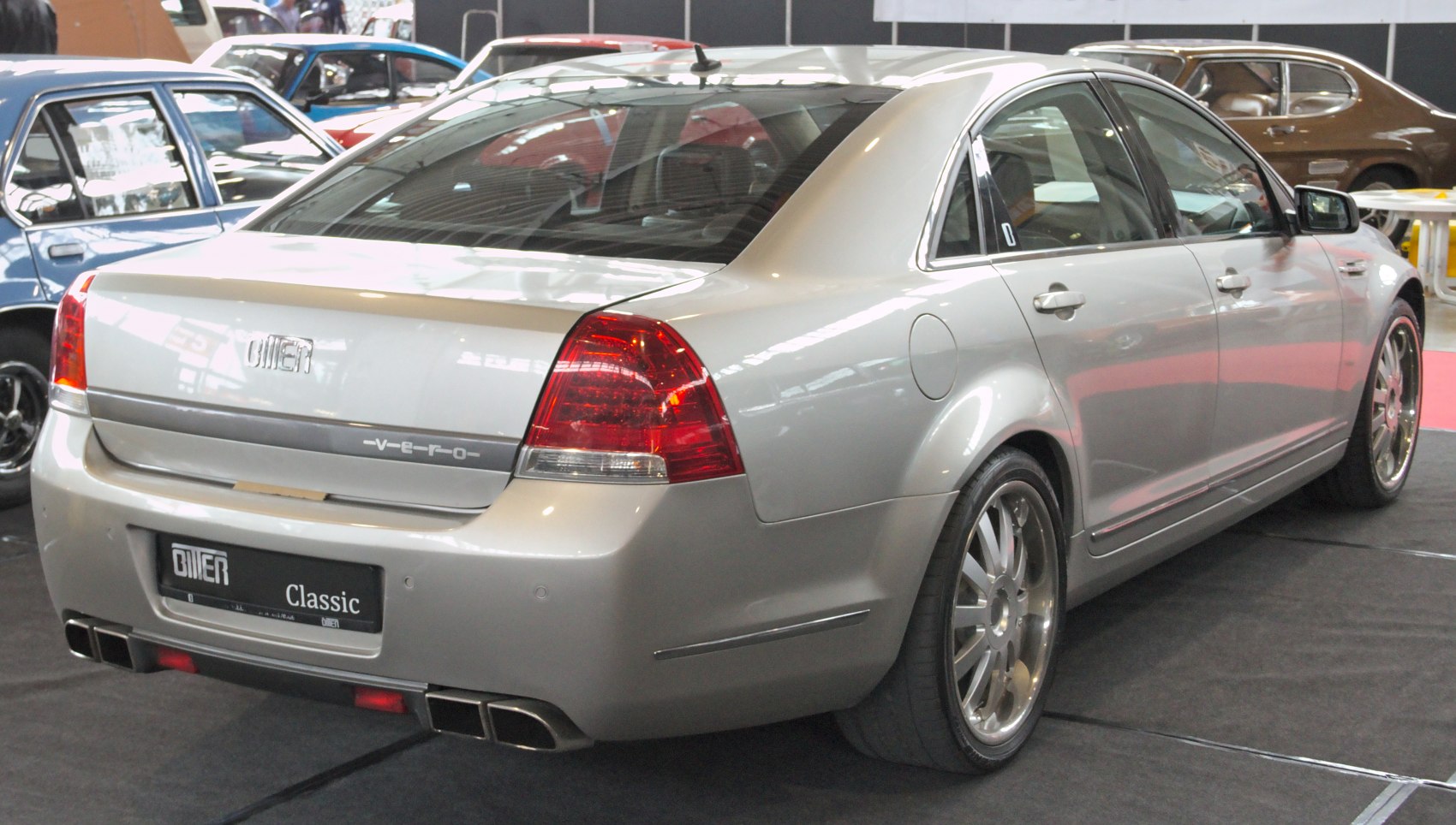 Rear view of silver luxury sedan with distinctive taillights and dual exhausts