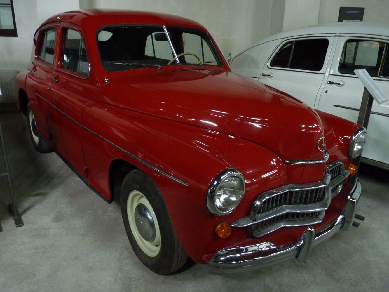 Red vintage sedan with chrome grille and round headlights
