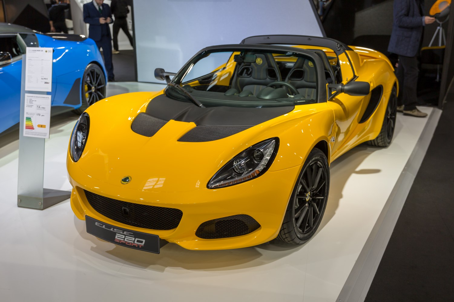 Yellow sports roadster with black hood vents and visible interior seating