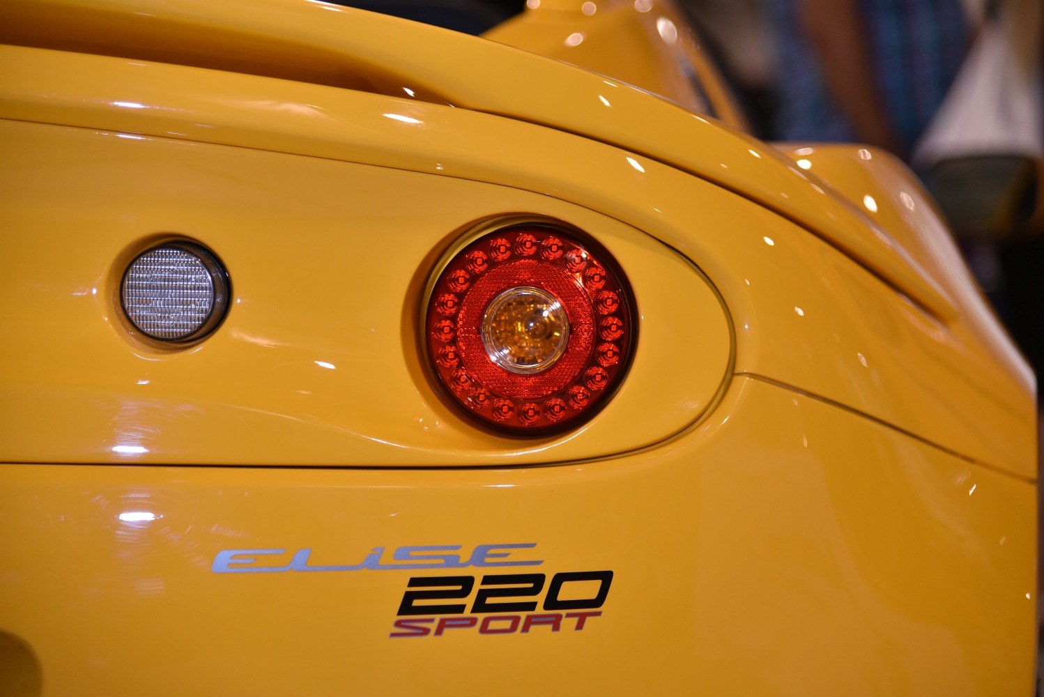 Close-up of rear light and Elise 220 Sport badge on yellow car