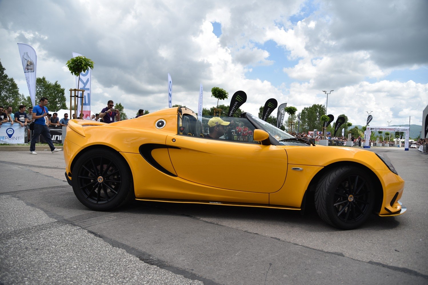 Yellow sports coupe with black alloy wheels and side air intake vents