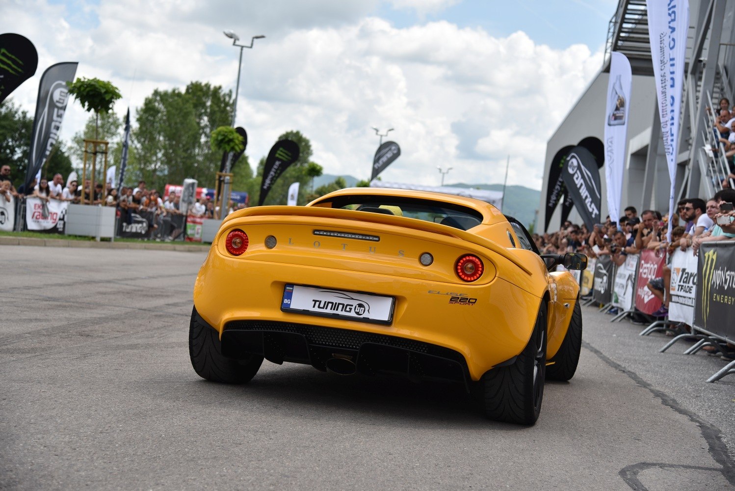 Yellow sports coupe rear with round tail lights and diffuser