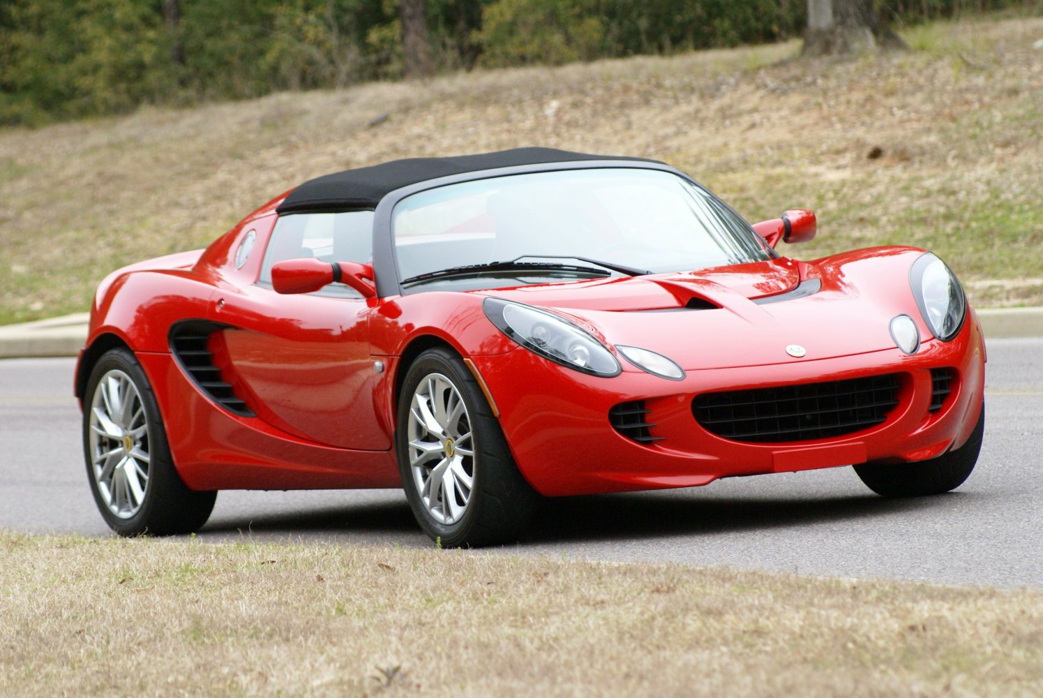 Red convertible sports car with sleek aerodynamic body and alloy wheels.