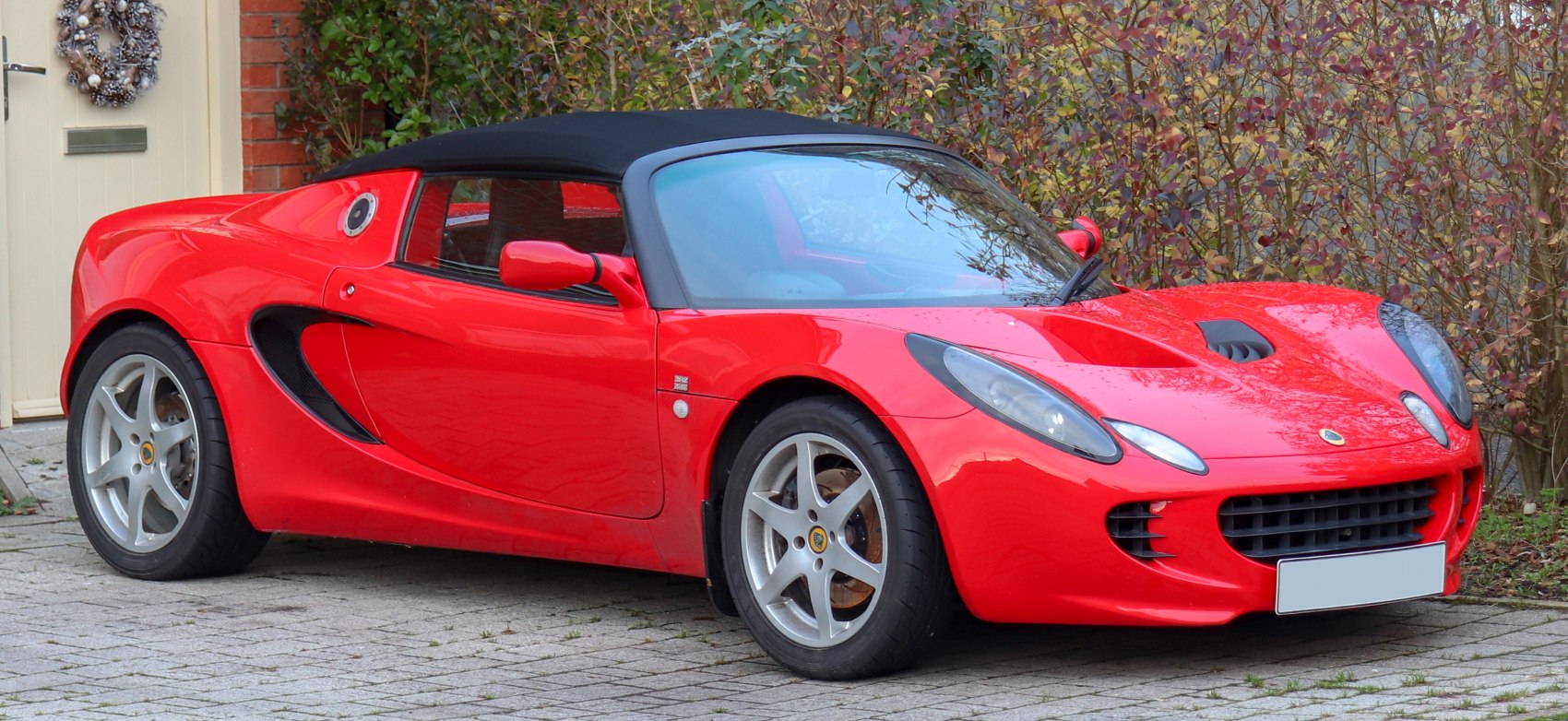 Red convertible sports car with aerodynamic body and alloy wheels