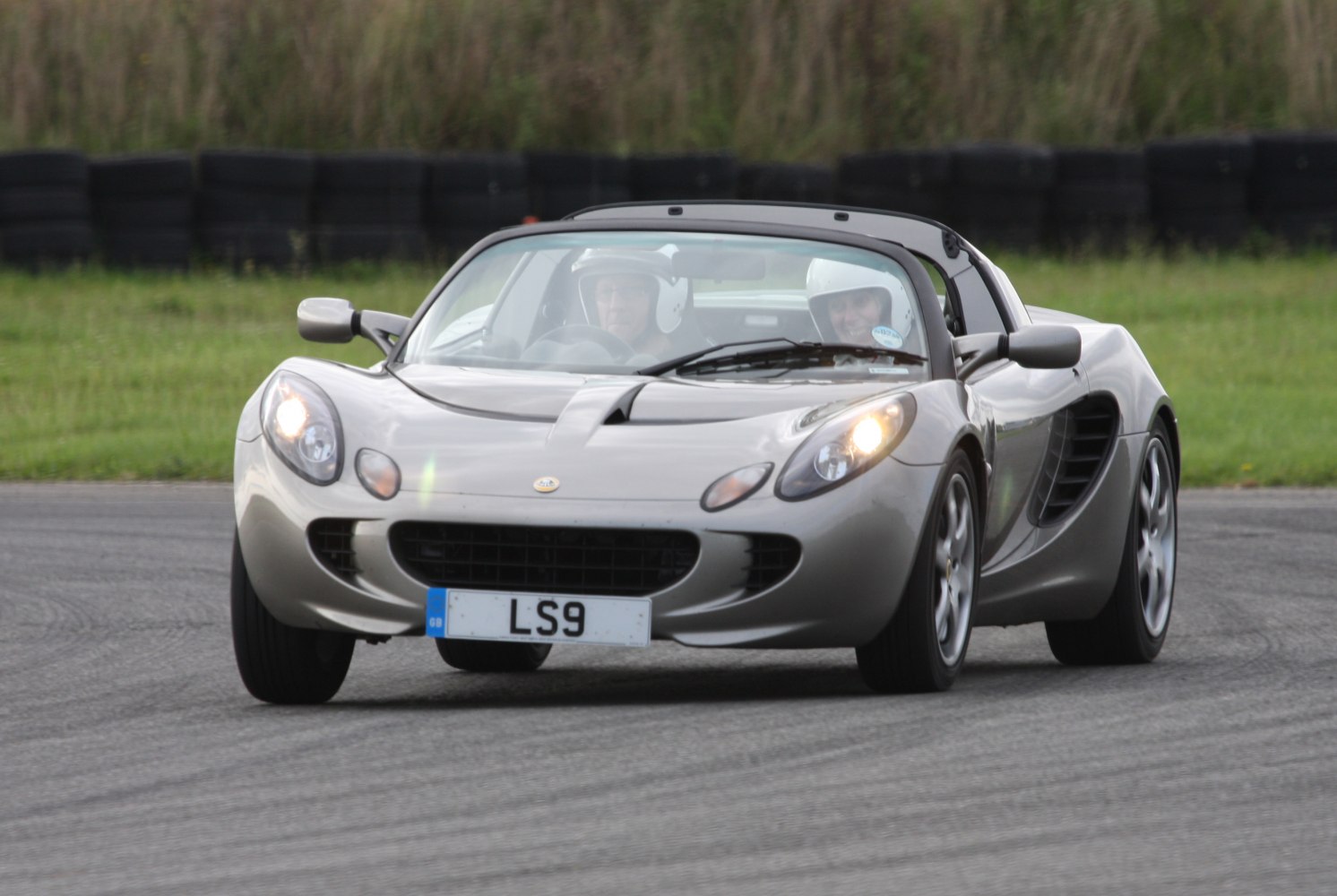 Front view of a sleek lightweight sports car with aerodynamic body and rounded headlights.