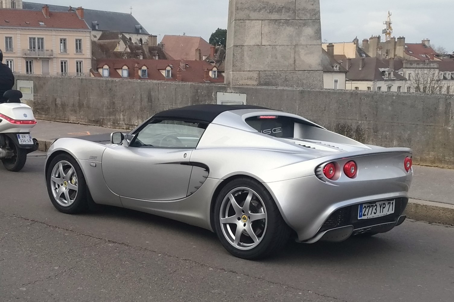 Silver sports car rear and side with round taillights and aerodynamic curves