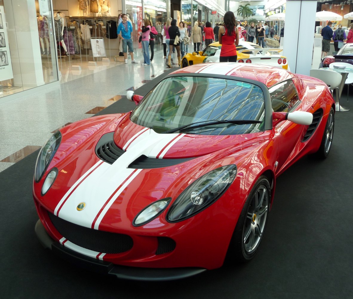 Red sports coupe with white racing stripes and aerodynamic features