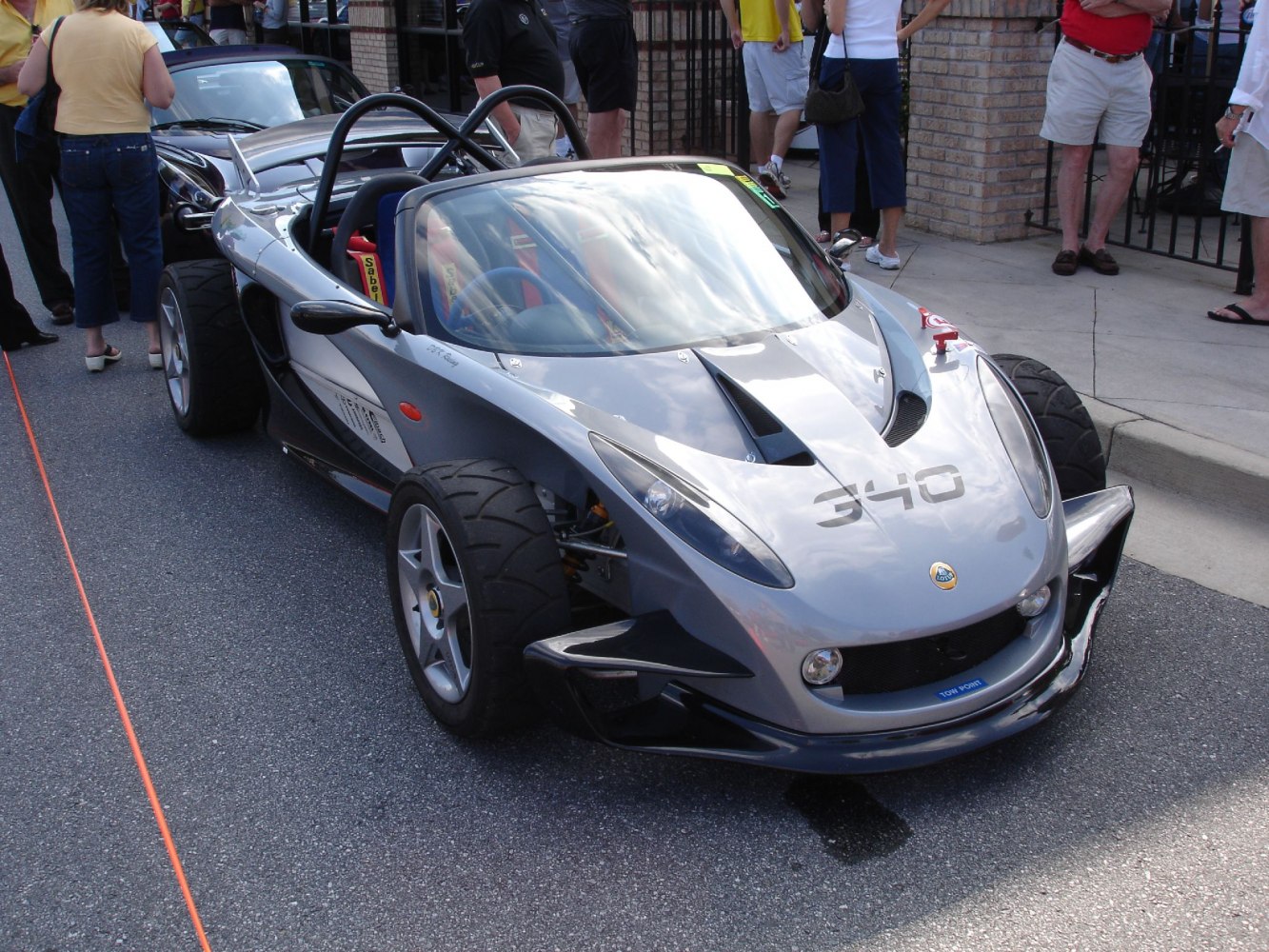 Open cockpit race car with aerodynamic body and racing wheels