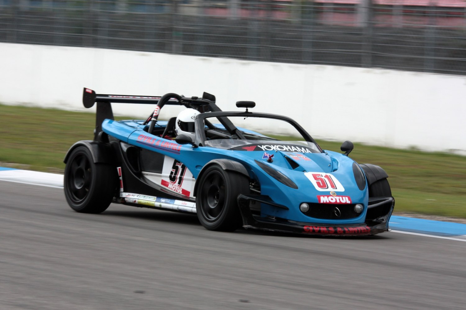 Lightweight open cockpit racing car with rear wing and aerodynamic body