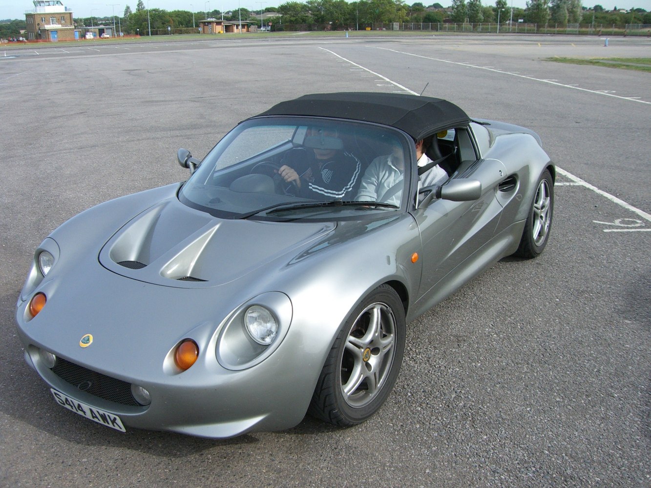 Silver convertible sports car with front vents and round headlights
