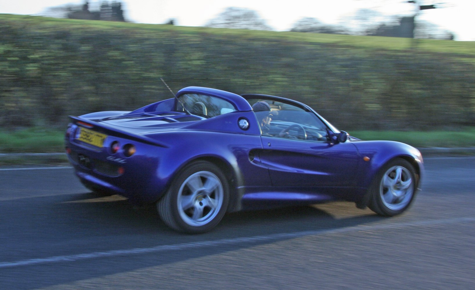 Lightweight open-top sports coupe with rounded wheel arches and rear spoiler
