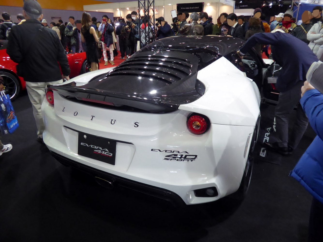 Rear of a sports car with carbon fiber spoiler and rear louver vents
