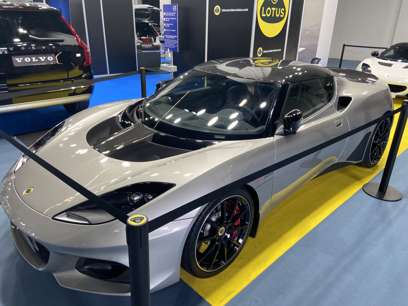 Silver sports car with carbon fiber hood and black alloy wheels.