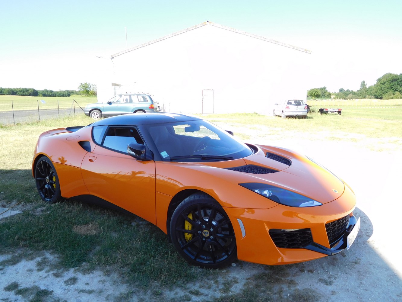 Orange sports coupe with aerodynamic vents and black wheels
