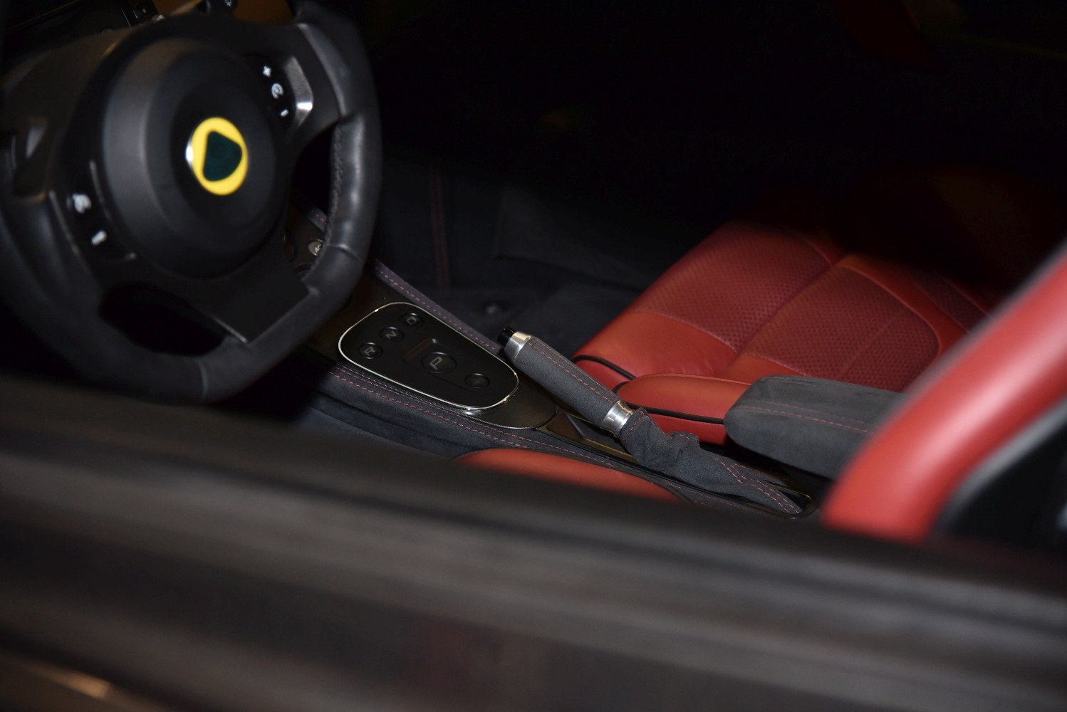 Red leather seats, black suede handbrake, and branded steering wheel interior