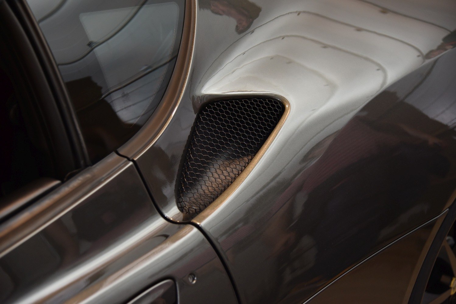 Close-up of sleek side air vent with aerodynamic mesh grille