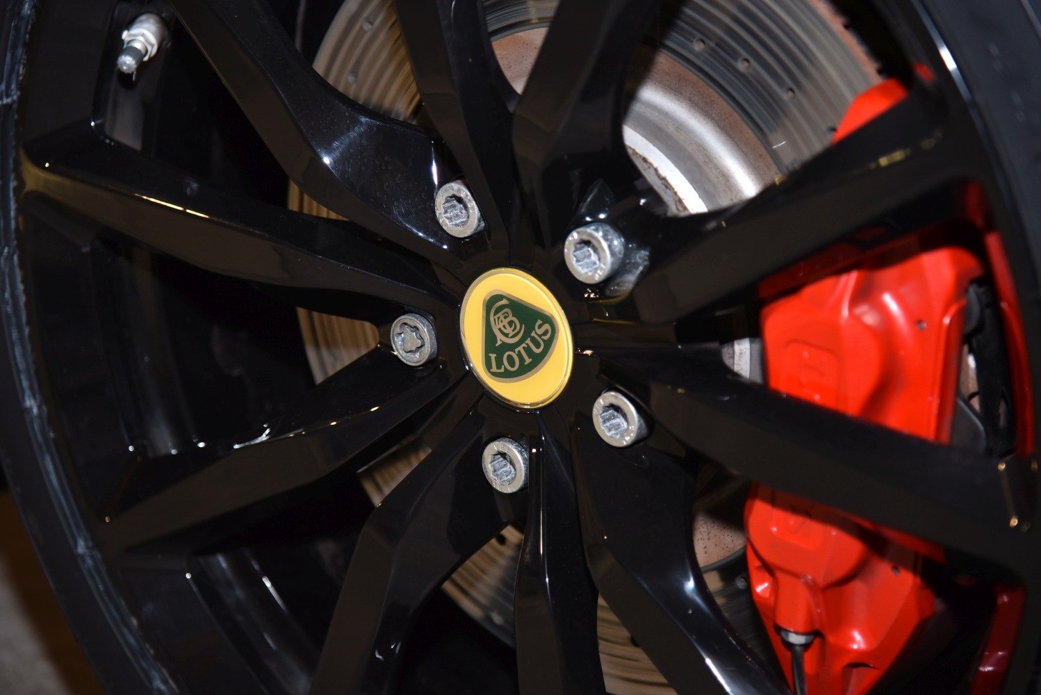 Black alloy wheel with red brake caliper and brake disc