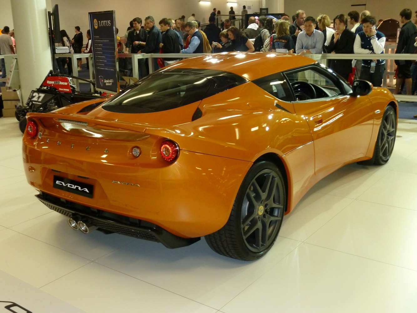 Sporty coupe rear with round tail lights and dual exhaust in orange.