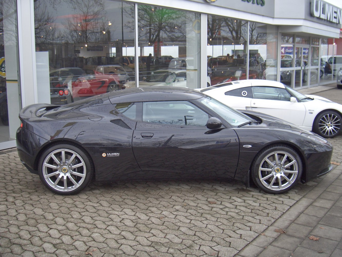 Side profile of a sports coupe with aerodynamic design and alloy wheels
