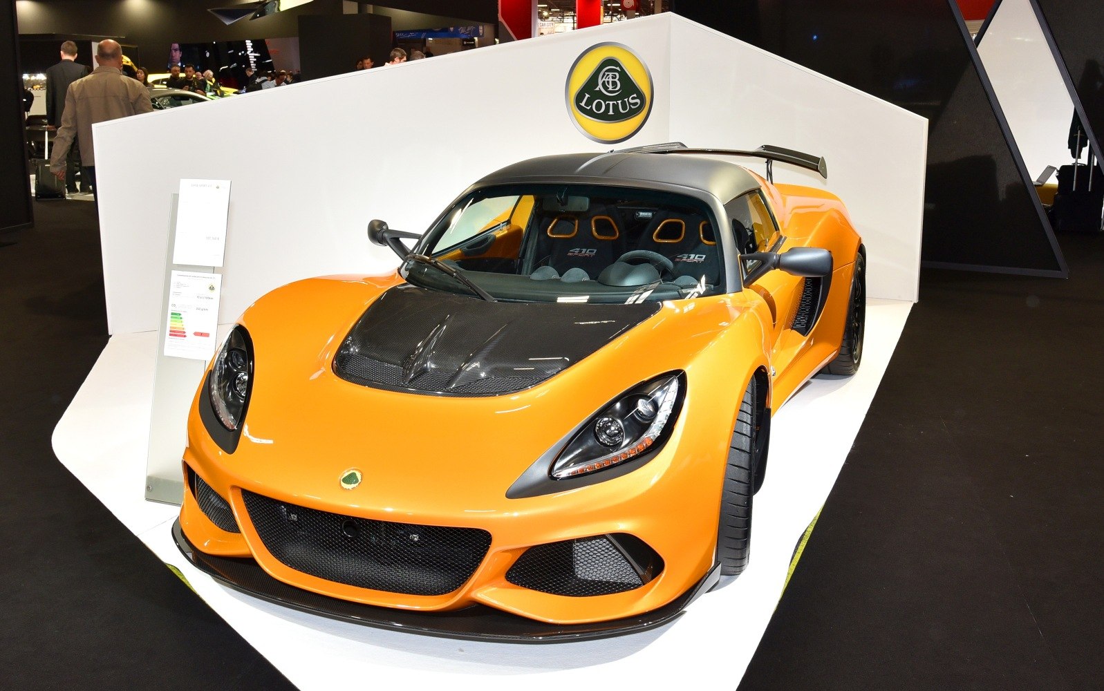 Front view of orange sports car with carbon fiber hood and aerodynamic design