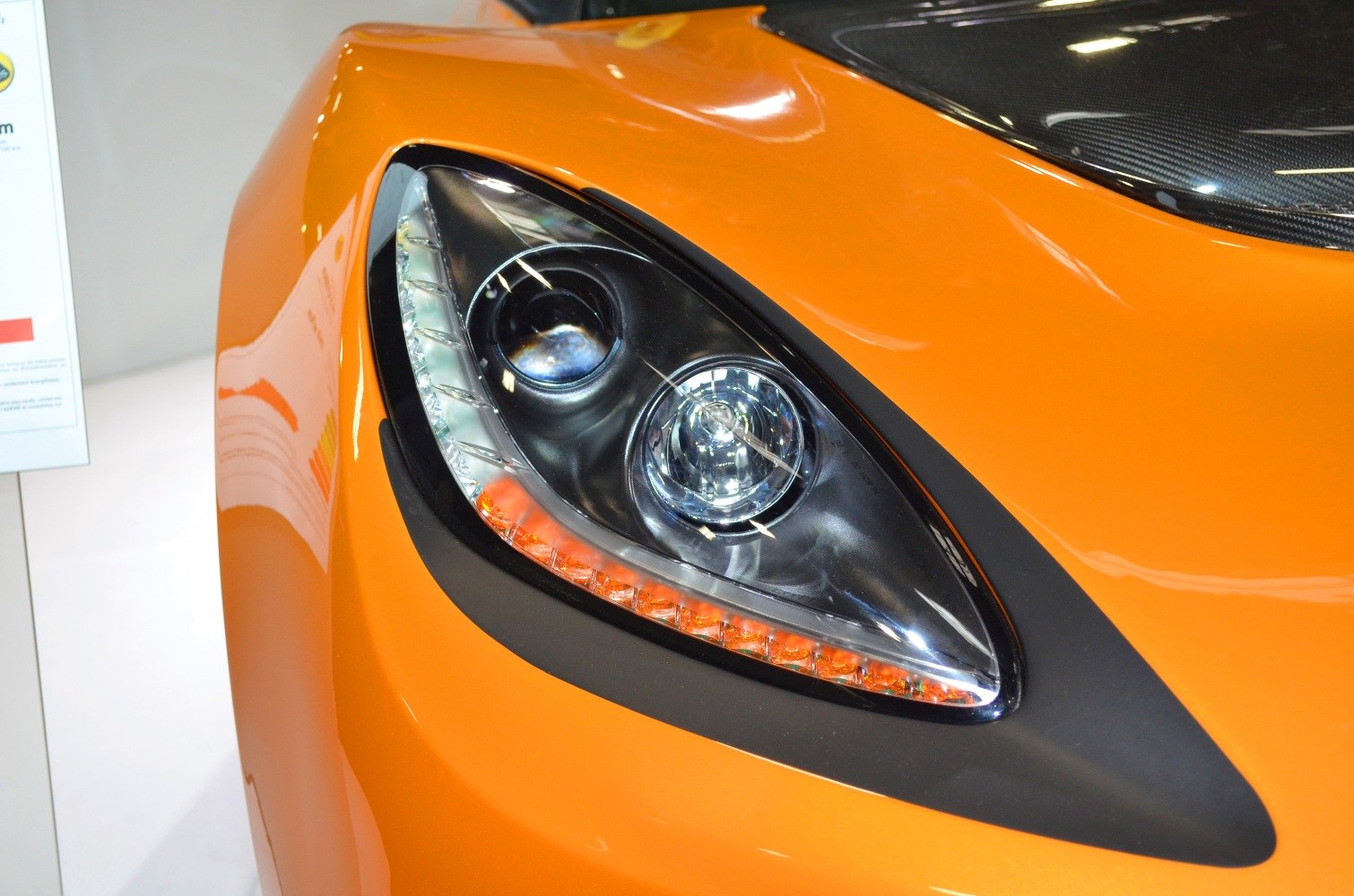 Close-up of sharp headlight with LED strip and orange front fender