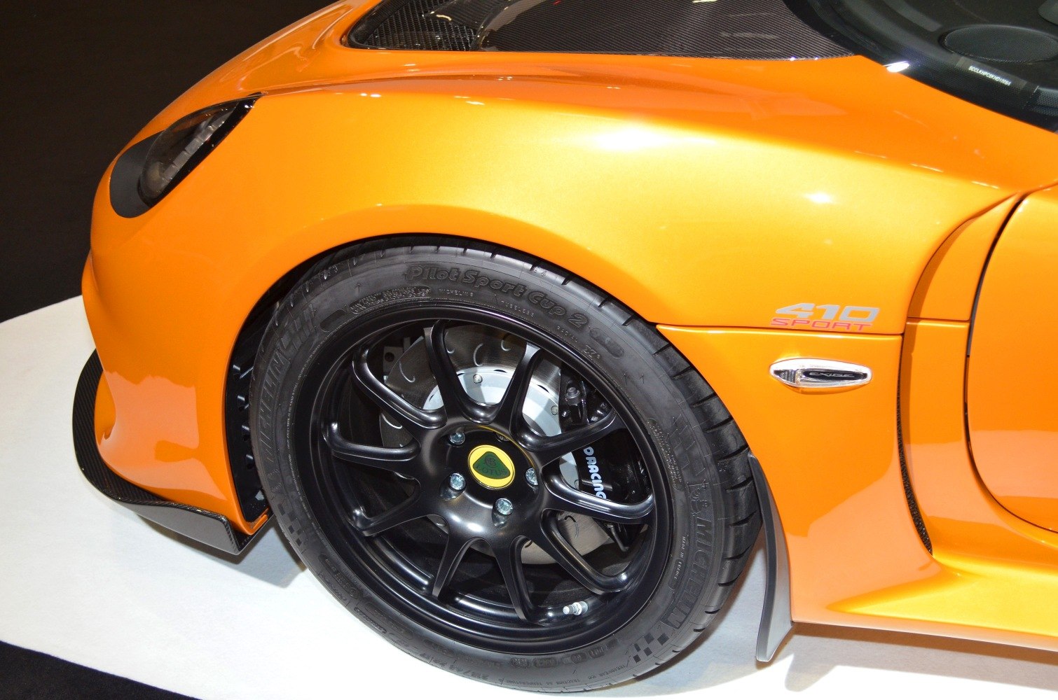 Front wheel with black alloy rim and brake disc, orange fender with 410 Sport badge