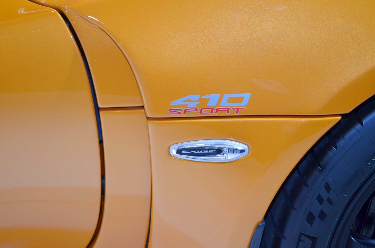 Close-up of 410 Sport badge and side indicator on orange body panel