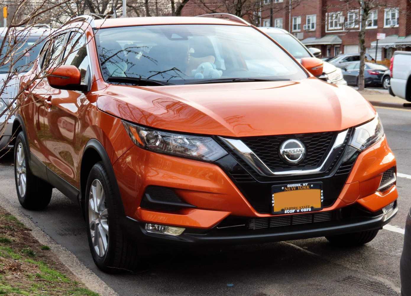 Front view of orange compact SUV with LED headlights and distinct grille design