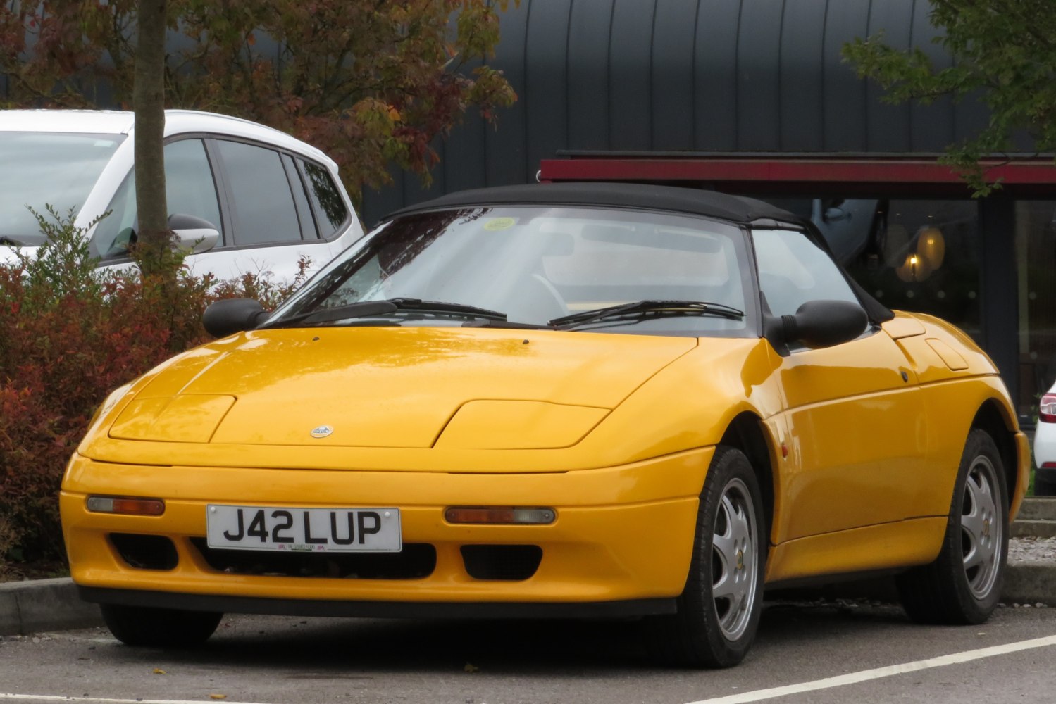 Yellow convertible sportscar with pop-up headlights and soft top roof
