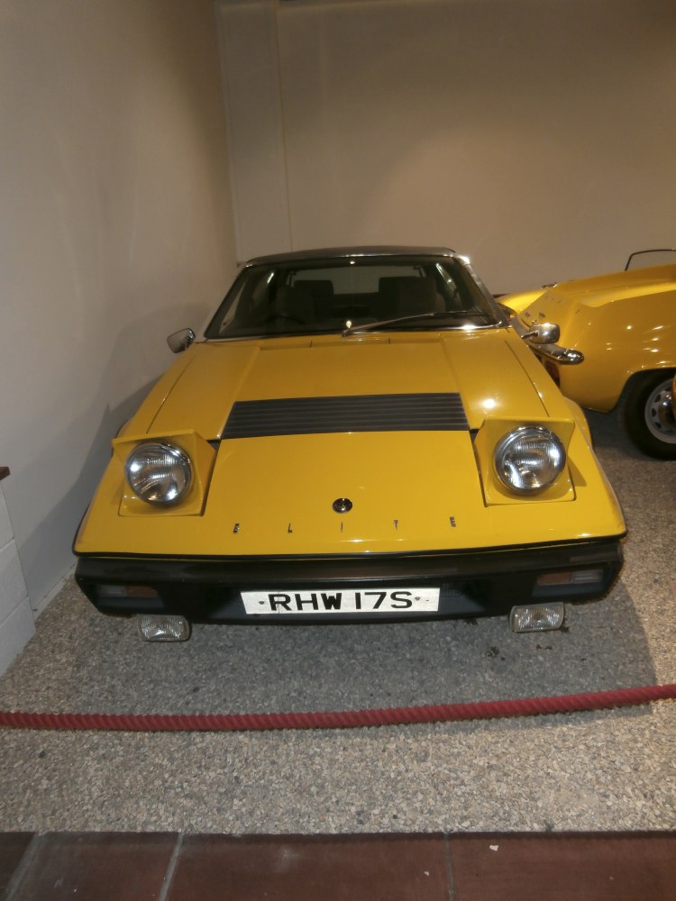 Yellow classic sports car front with pop-up headlights and fog lamps.