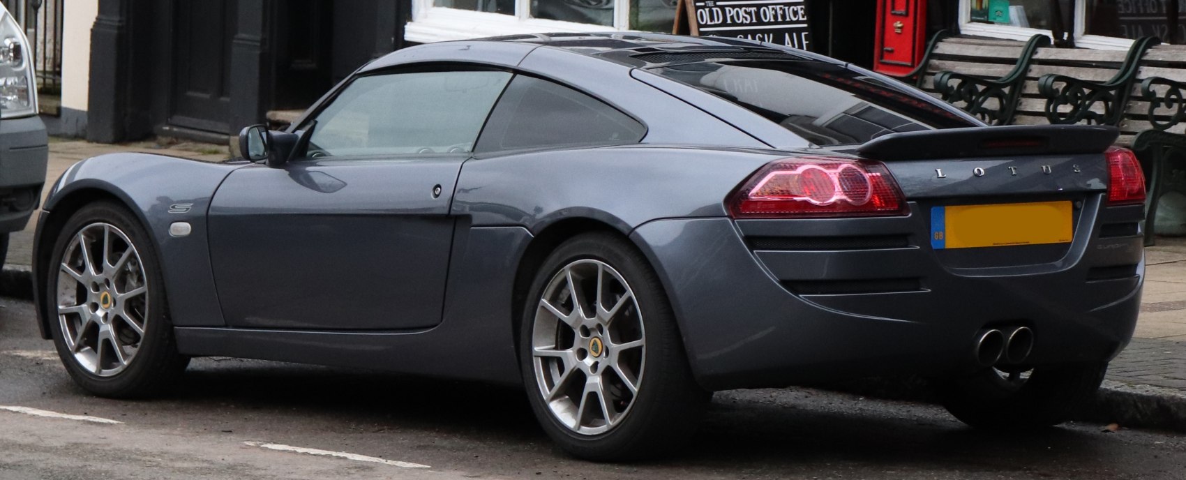Sporty coupe rear and side view with spoiler and dual exhausts