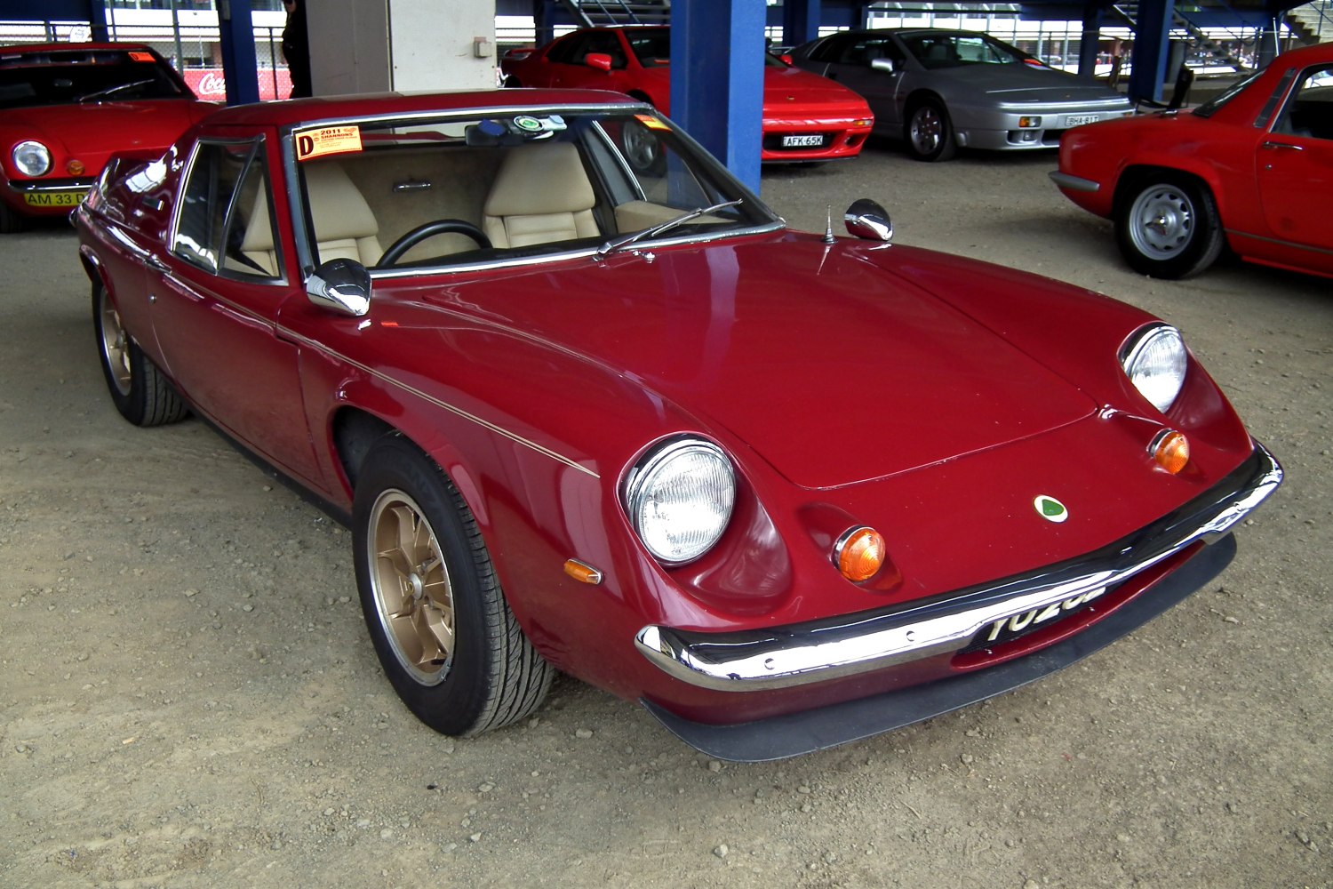 Front view of a vintage sports coupe with round headlights and red paint