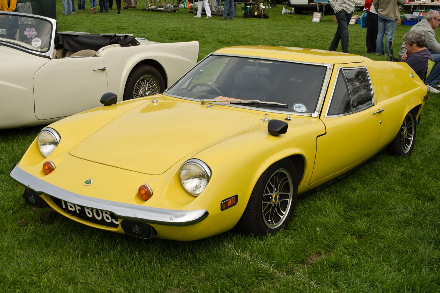 Yellow vintage sports coupe with pop-up headlights and chrome bumper