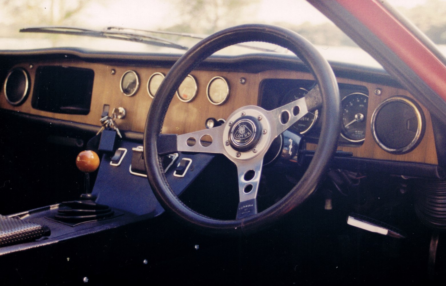 Three-spoke steering wheel and wood dashboard with analog gauges