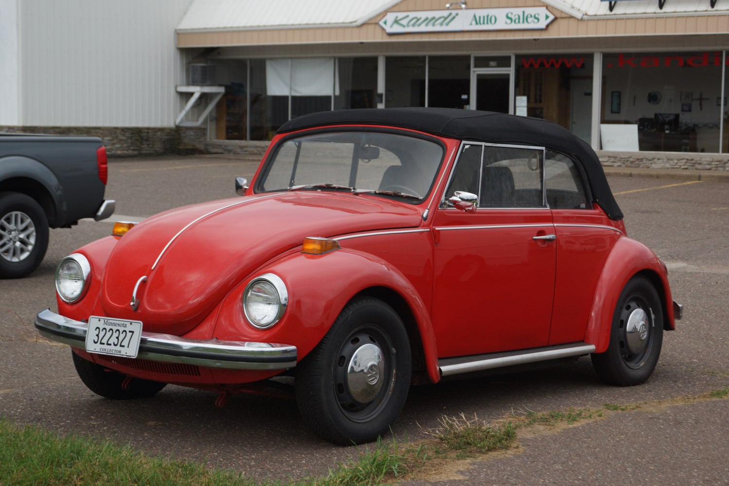 Red vintage convertible with black folding roof and rounded fenders