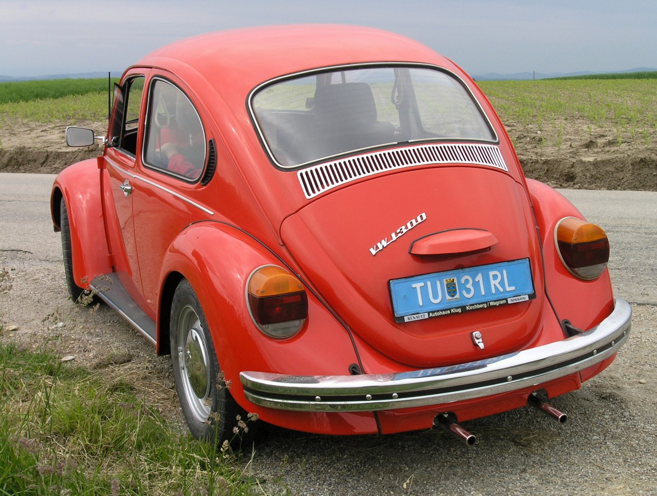 Rear view with dual exhaust, vintage tail lights, curved rear window