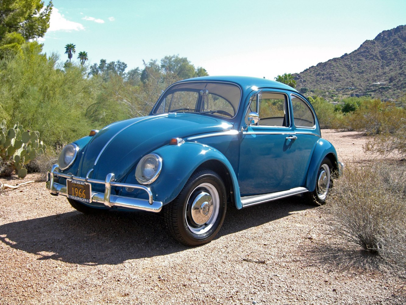 Vintage rounded body with chrome bumpers and hubcaps in front side view.
