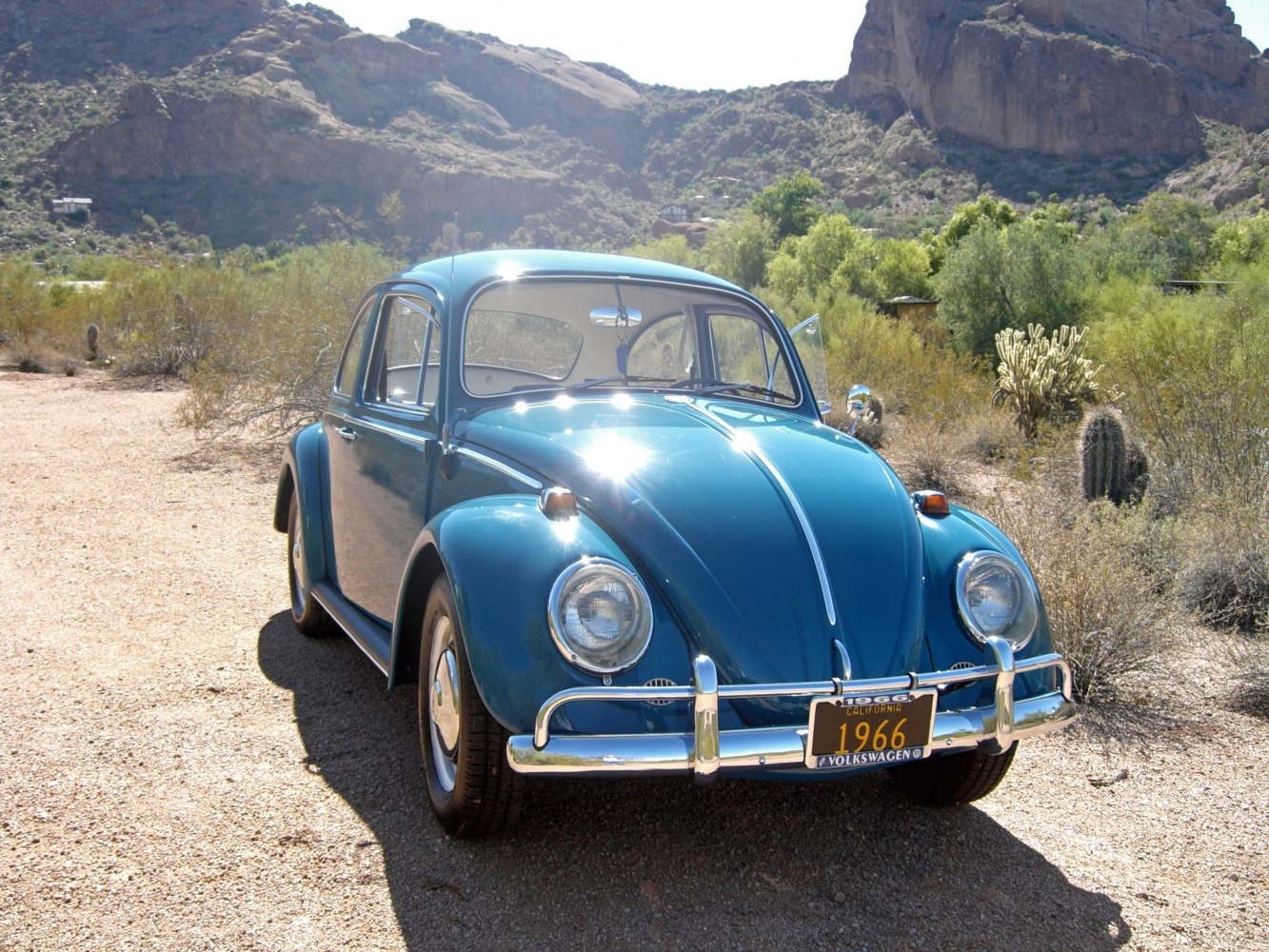 Vintage rounded headlights and chrome bumper on a blue classic car