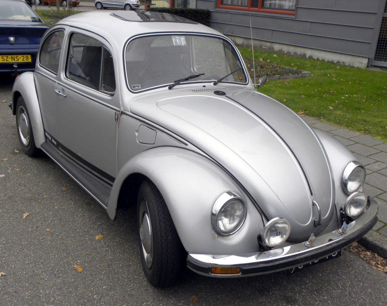 Silver vintage Volkswagen Beetle front side view with round headlights