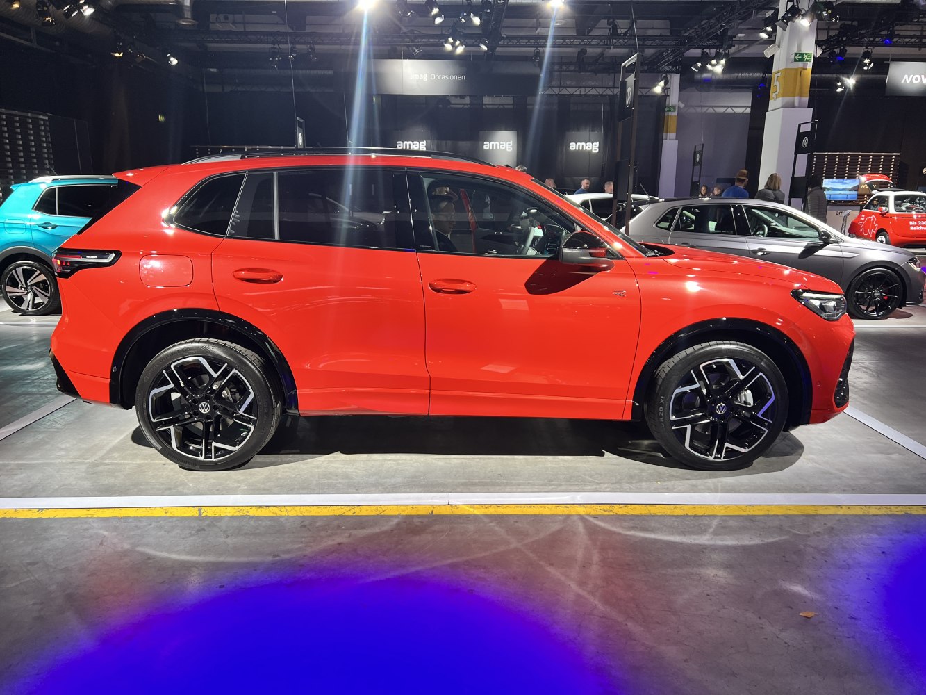 Side profile of a red SUV with black alloy wheels