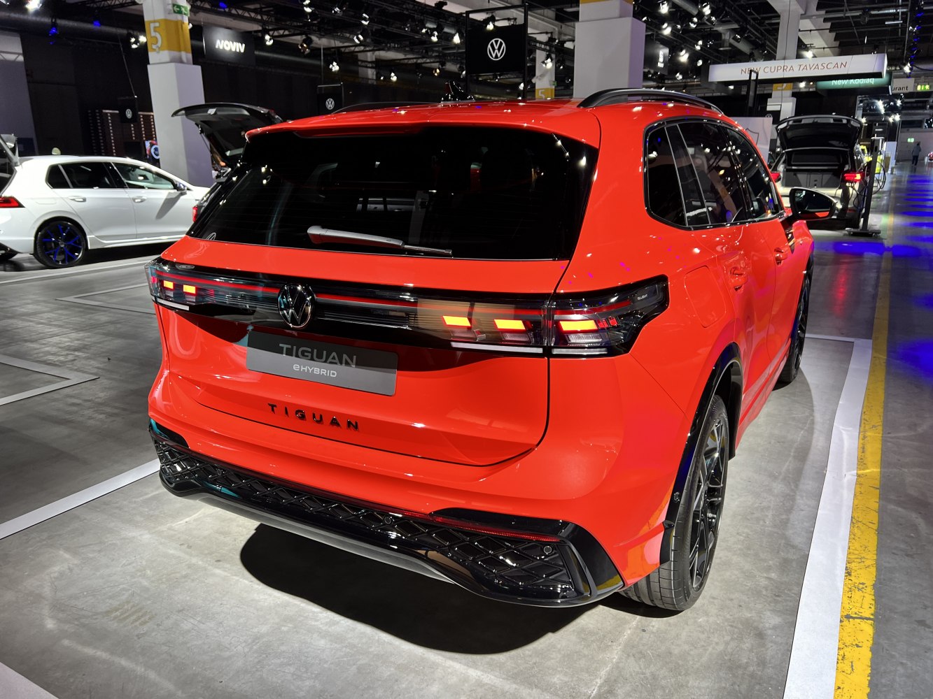 Red hybrid SUV rear with modern taillights and sporty black lower bumper.