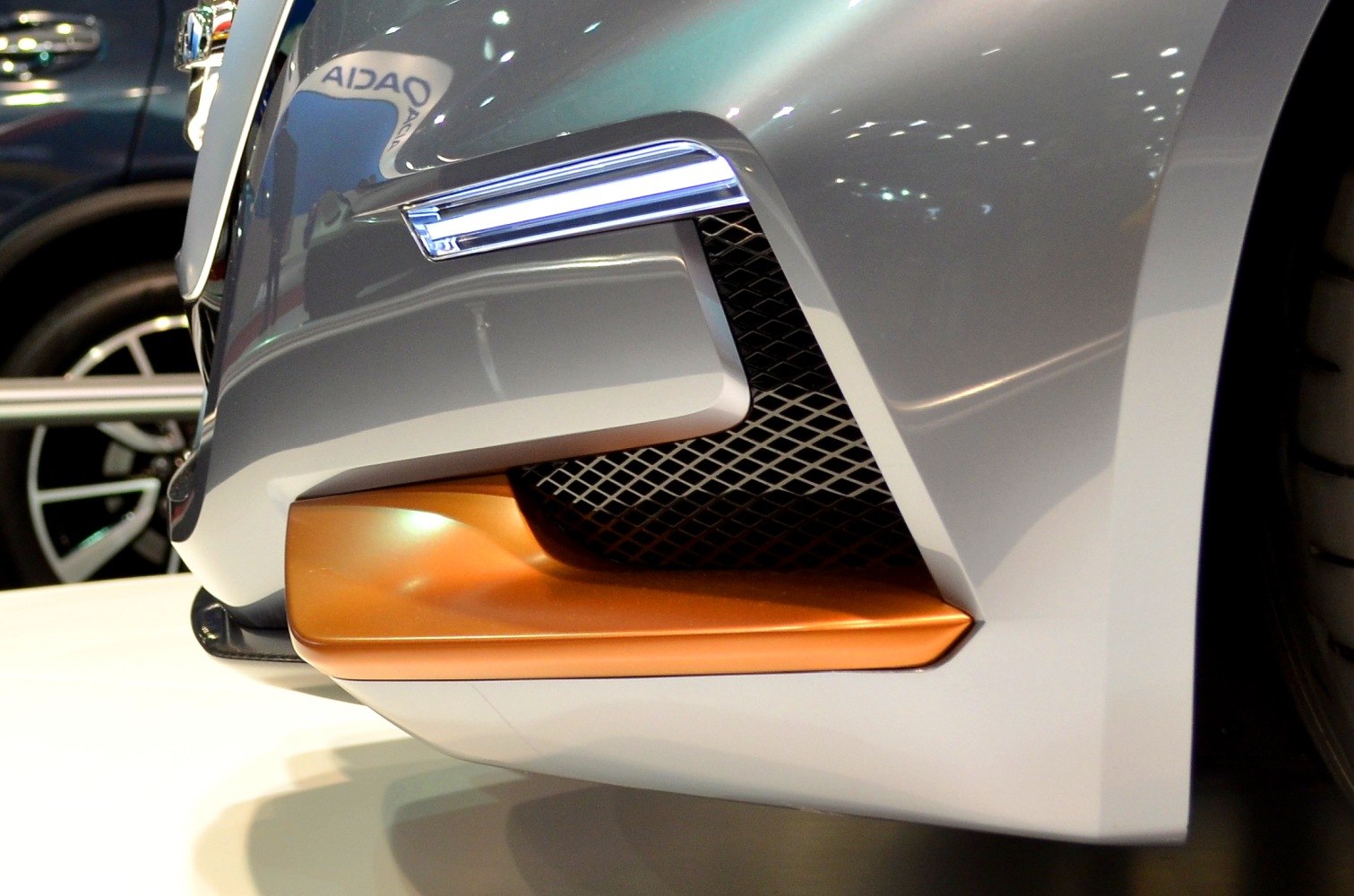 Close-up of front bumper with aerodynamic design and grille.
