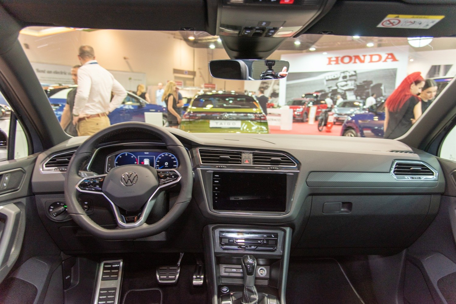 Modern car interior dashboard with digital display and steering wheel.